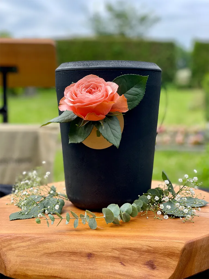 Kohleurne bei einer Trauerfeier mit Rose